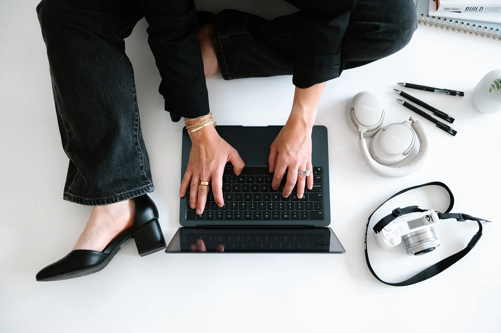 Brooke Kennison typing on a laptop on the studio floor, seen from above